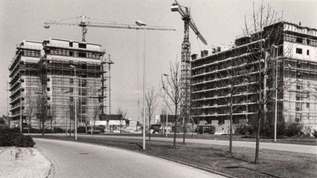 Straten van Zuidbroek. Staande op de Euratomsingel dit uitzicht op de twee in aanbouw zijnde flats aan weerszijden van de Ardennenlaan